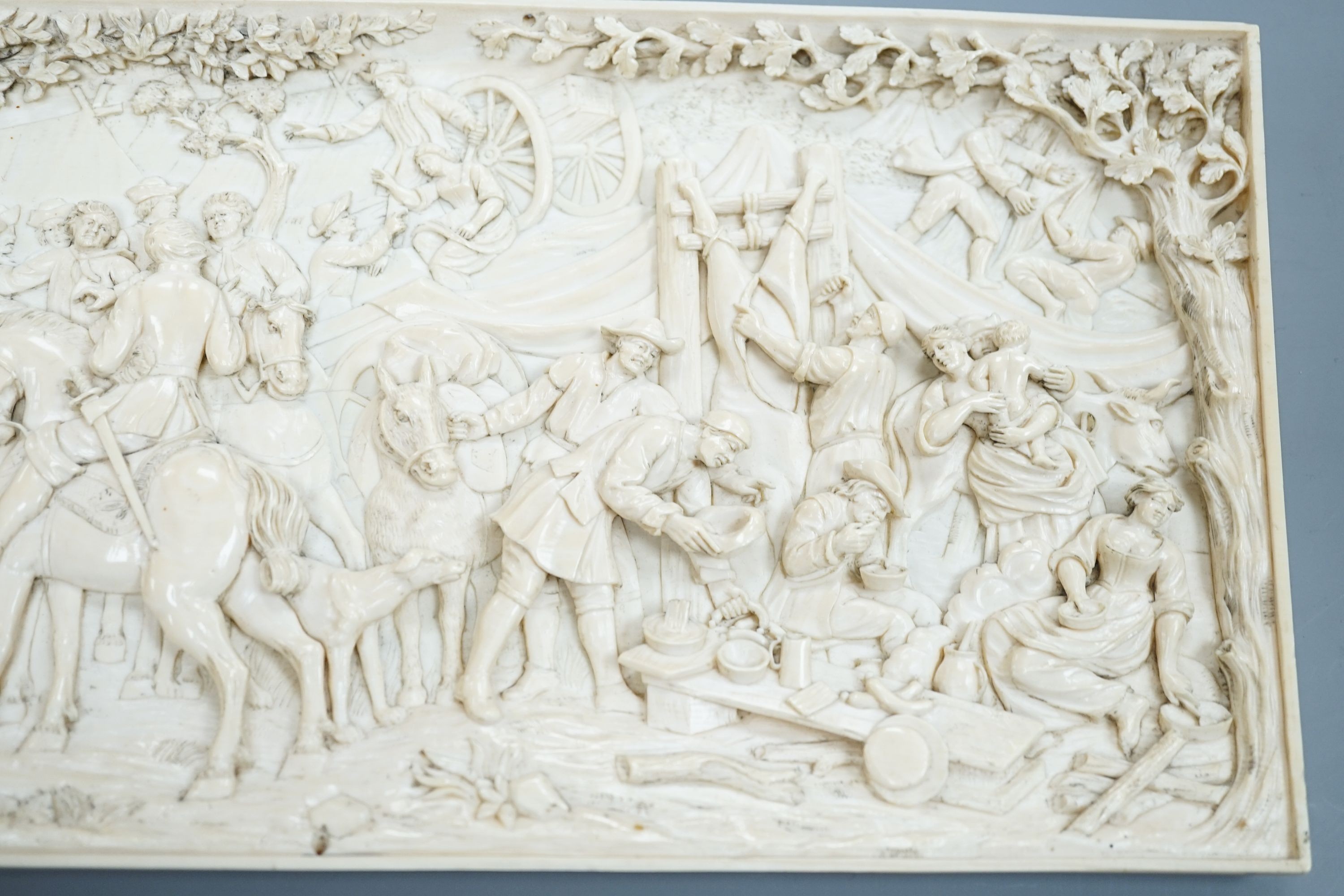 An 18th century Flemish carved ivory plaque (initials OF?) with scenes of hunters and village life, 15 x 28cm